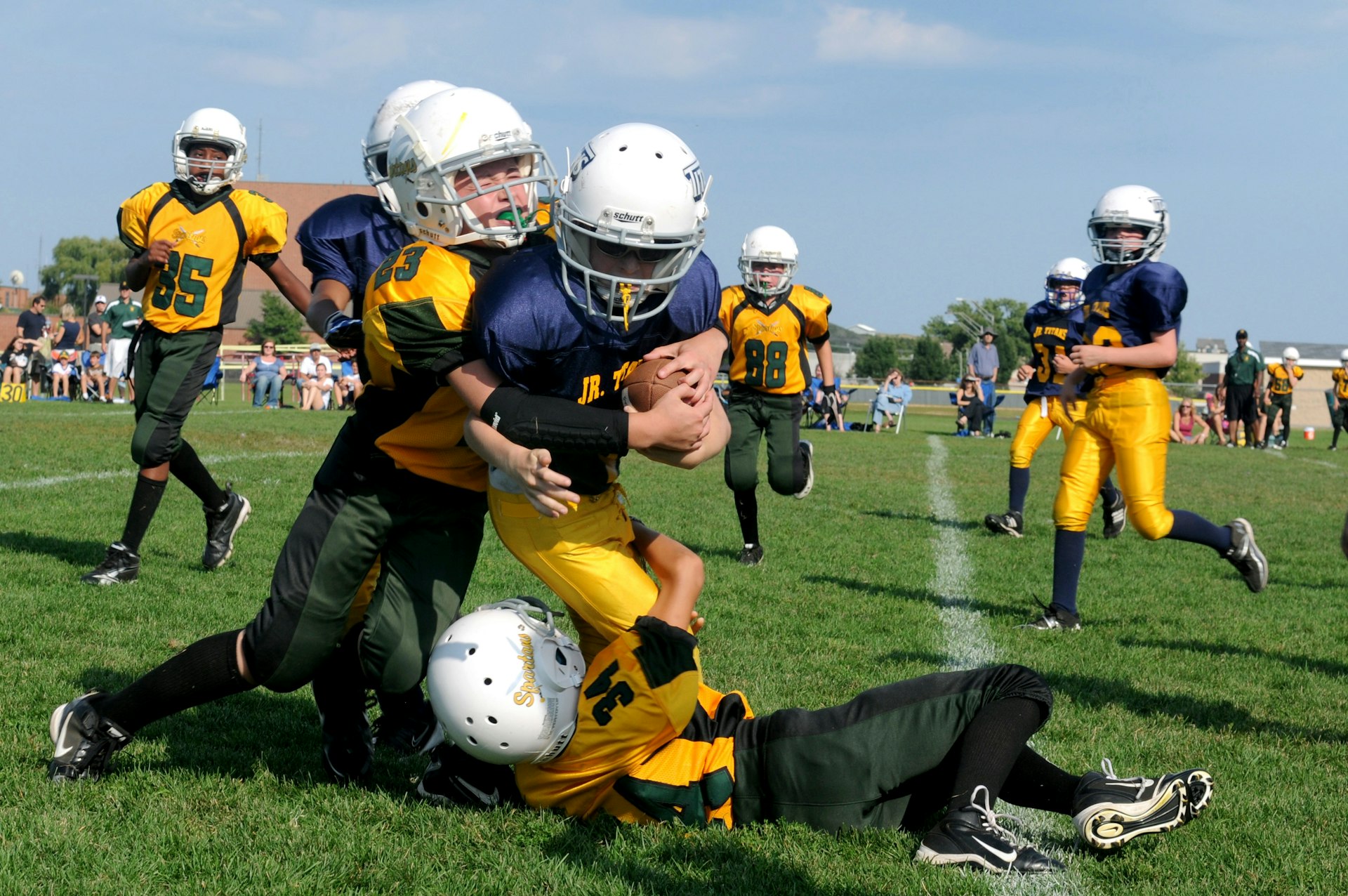 football players struggling to hold the football during daytime